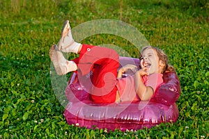 Young girl playing tricks in inflatable armchair