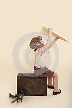 Young girl playing with vintage paper airplane