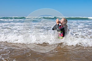 Young girl playing in waves at a New Zealand beach