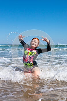 Young girl playing in waves at a New Zealand beach