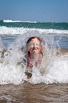 Young girl playing in waves at a New Zealand beach