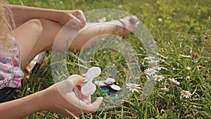 Young girl playing with a white spinner on the lawn on a summer sunny day.