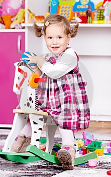 Young girl playing on wooden horse