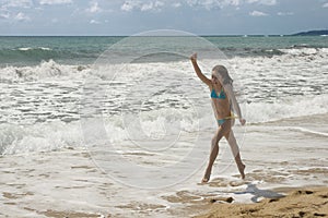 Young girl plays on the beach III