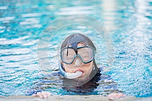 Young girl in pool with swimming mask and snorkel