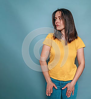 Young girl, portrait on blue background, head turned to the left