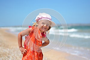 Young girl posing in orange dress on the beach