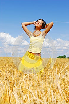 Young girl posing on plant of wheat