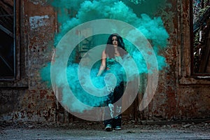 Young girl posing with turquoise smoke