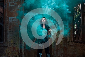 Young girl posing with turquoise smoke