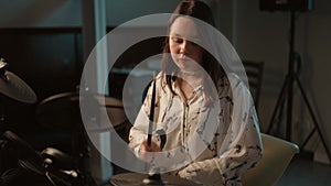 A young girl practices at a music school playing an electronic drum kit.