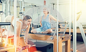 Young girl practicing pilates stretching exercises on combo chair