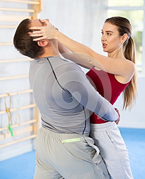 Young girl practicing self-defense techniques in pair with middle-aged man