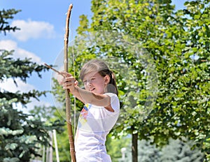 Young girl practising with a bow and arrow