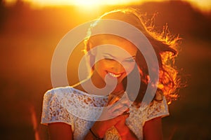 A young girl prays at sunset