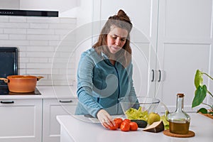 young girl preparing a salad in the kitchen
