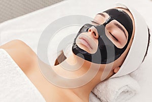 Young girl with purifying black face mask