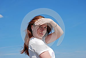 The young girl put her hand to her forehead, closed from the sun and looking into the distance.