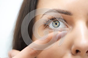 Young girl puts on contact lenses