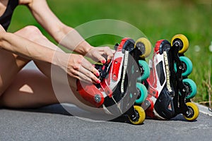 Young girl putting on inline skates