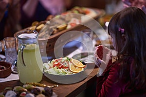 A young girl raises her hands in prayer as she prepares for her iftar meal during the holy month of Ramadan, embodying