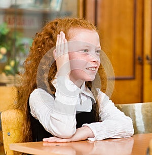 Young girl raising hand knowing the answer to the question