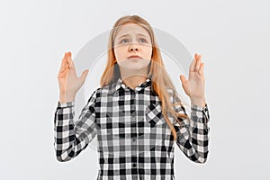 Young girl raising hands dismay and disappointment, frustrated by a bad situation, standing over white background in casual shirt