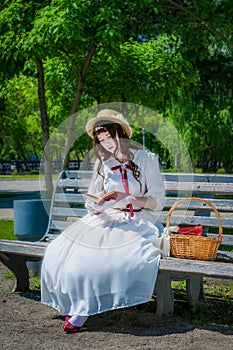 Young girl is reading a book sitting on a bench