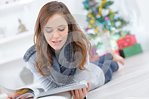 Young girl reading while laying on floor