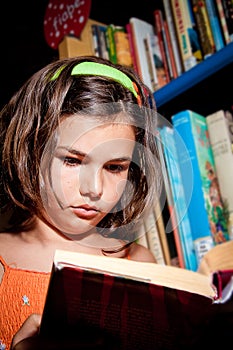 Young girl reading in library