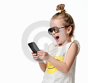 Young girl reading texting sms on the cellphone mobile with touch screen in sunglasses