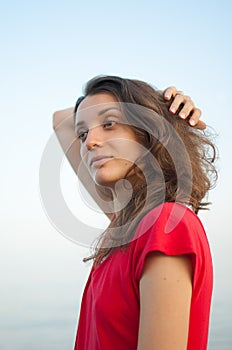 Young girl in red dress on the sea and blue background, summertime, travelling concepts