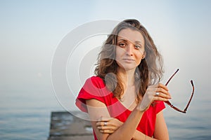 Young girl in red dress on the sea and blue background, summertime, travelling concepts