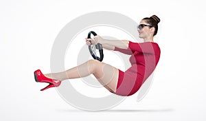 Young girl in red dress and sunglasses is driving a car steering wheel, auto concept