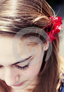 Young girl with red flower on her hair