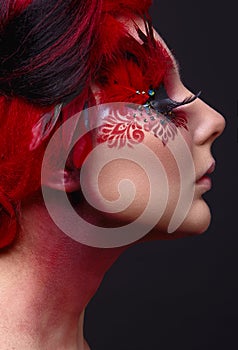 Young girl with red hair and creative ingenious makeup