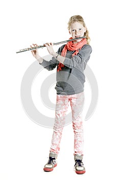 Young girl with red hair and freckles plays flute