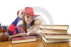 Young girl with red hat and her teddy bear at the table
