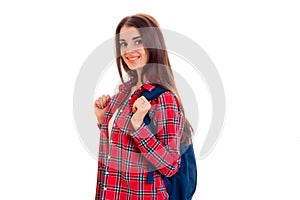 A young girl in a red Plaid Shirt and with a portfolio on the shoulders of smiling and looking directly