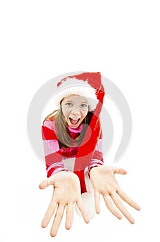 Young girl in red Santa hat. Looking up expects gifts from Santa for Christmas