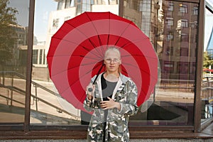 young girl with red umbrella in the city