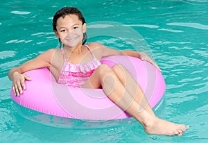 Young girl relaxes in swimming pool