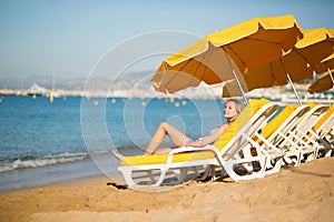 Young girl relaxing on a beach chair near the sea