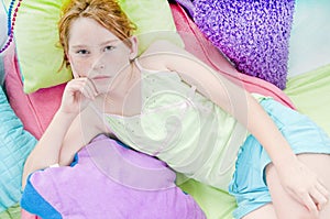 Young girl relaxing on cushions