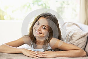 Young Girl Relaxing On Sofa At Home