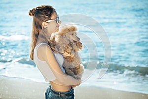 Young girl is resting with a dog on the sea.