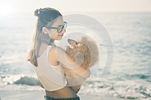 Young girl is resting with a dog on the sea.