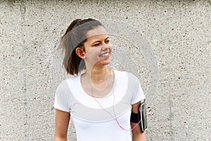 Young girl resting by wall. Joging outfit.