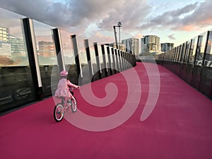 Young girl ride a bike on bright pink cycleway in Auckland New photo