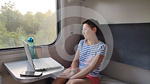 A young girl rides a train.